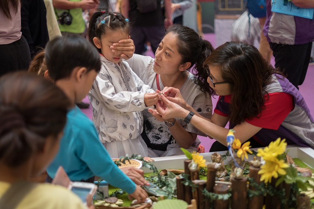 A kid closed her eyes and touched the ceramics art piece